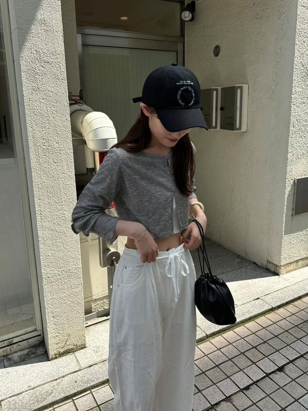 グレー系のTシャツ/カットソー、ホワイト系のその他パンツ、ブラック系のハットを着用したレディースの秋コーディネートの4枚目の写真