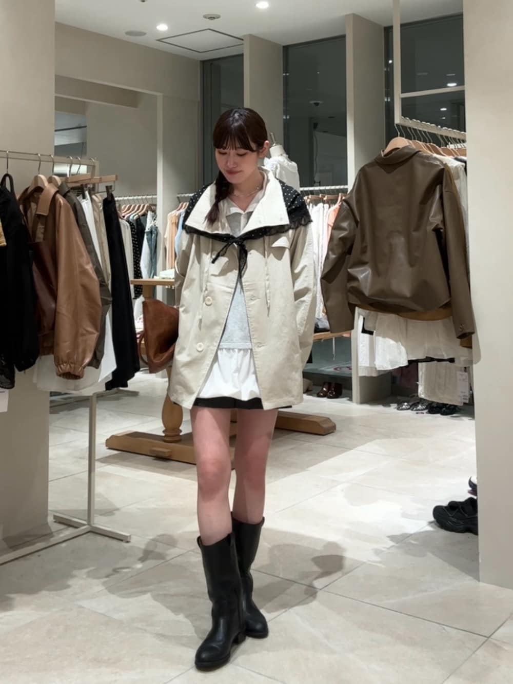 ホワイト系のトレンチコート、イエロー系のトートバッグ、グレー系のスカートを着用したレディースの春コーディネートの3枚目の写真