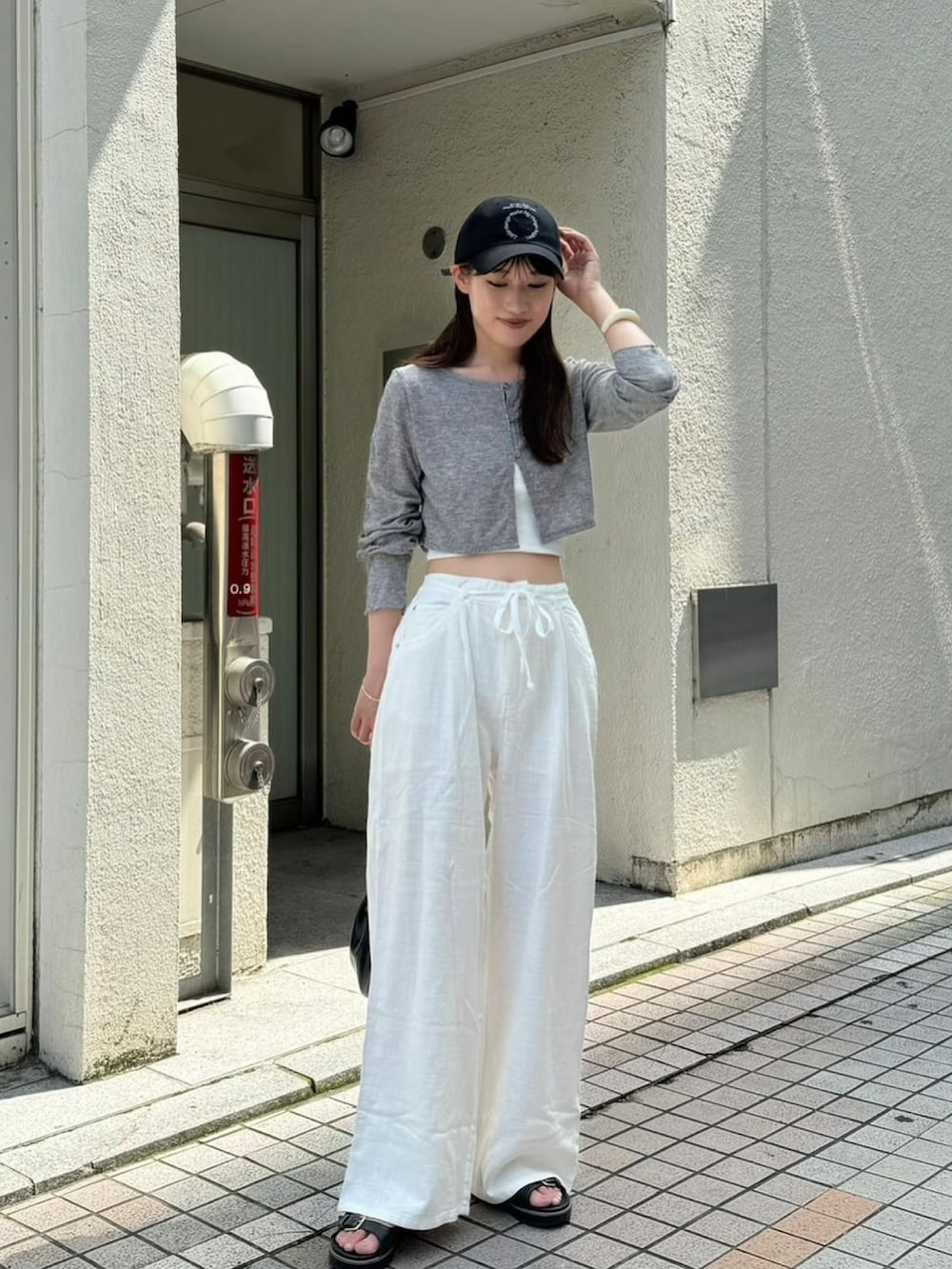 グレー系のTシャツ/カットソー、ホワイト系のその他パンツ、ブラック系のハットを着用したレディースの秋コーディネートの2枚目の写真