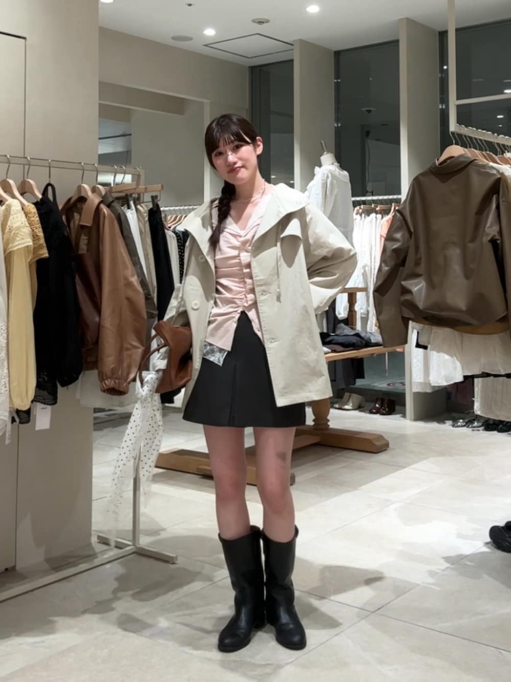 ピンク系のTシャツ/カットソー、ホワイト系のトレンチコート、グレー系のスカートを着用したレディースの春コーディネートの3枚目の写真