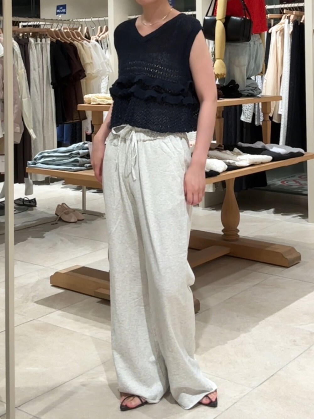 ブルー系のベスト、ホワイト系のスウェットパンツを着用したレディースの夏コーディネートの3枚目の写真