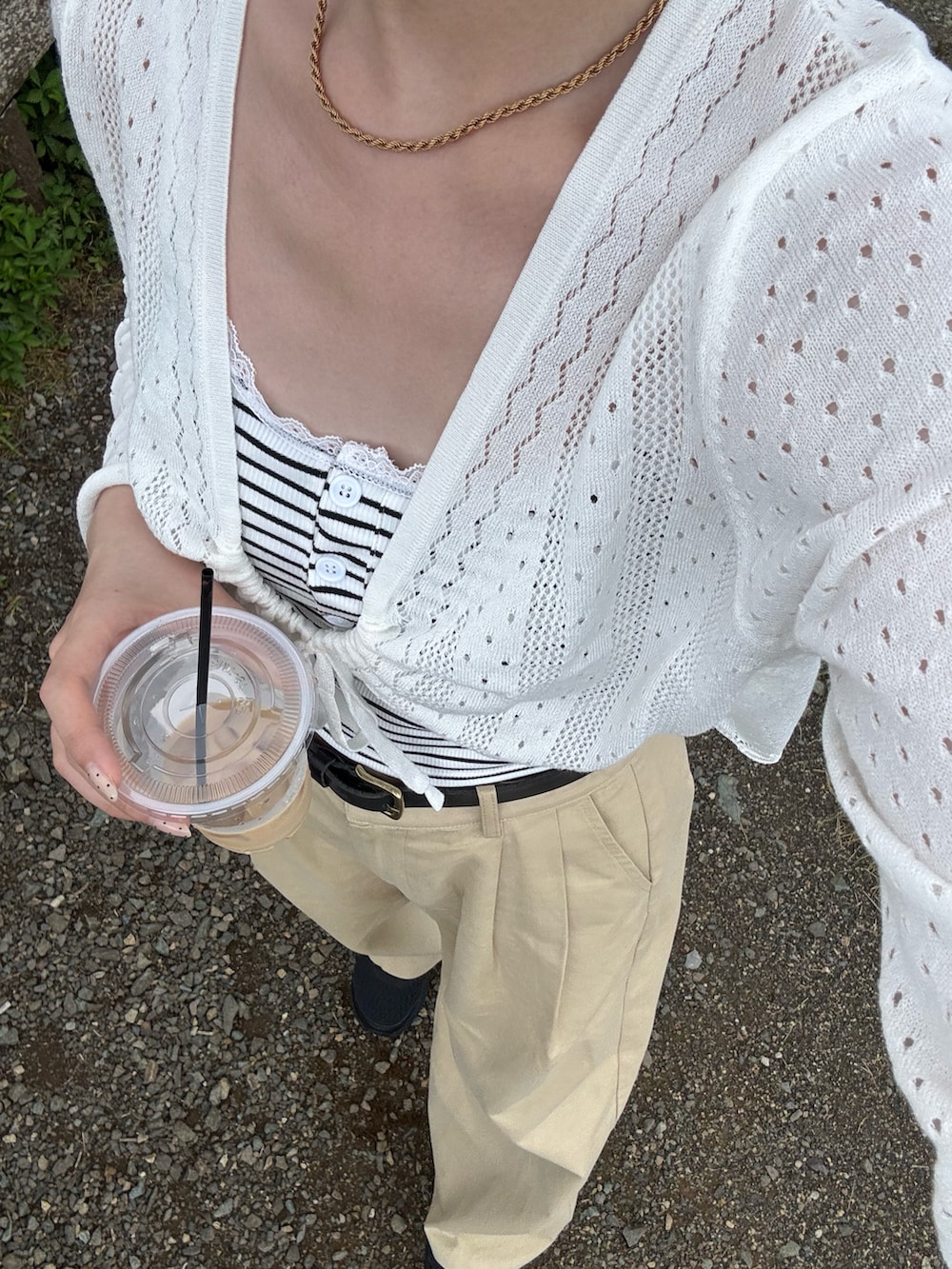 ホワイト系のカーディガン/ボレロ、ホワイト系のキャミソール、ベージュ系のチノパンツを着用したレディースの夏コーディネートの3枚目の写真