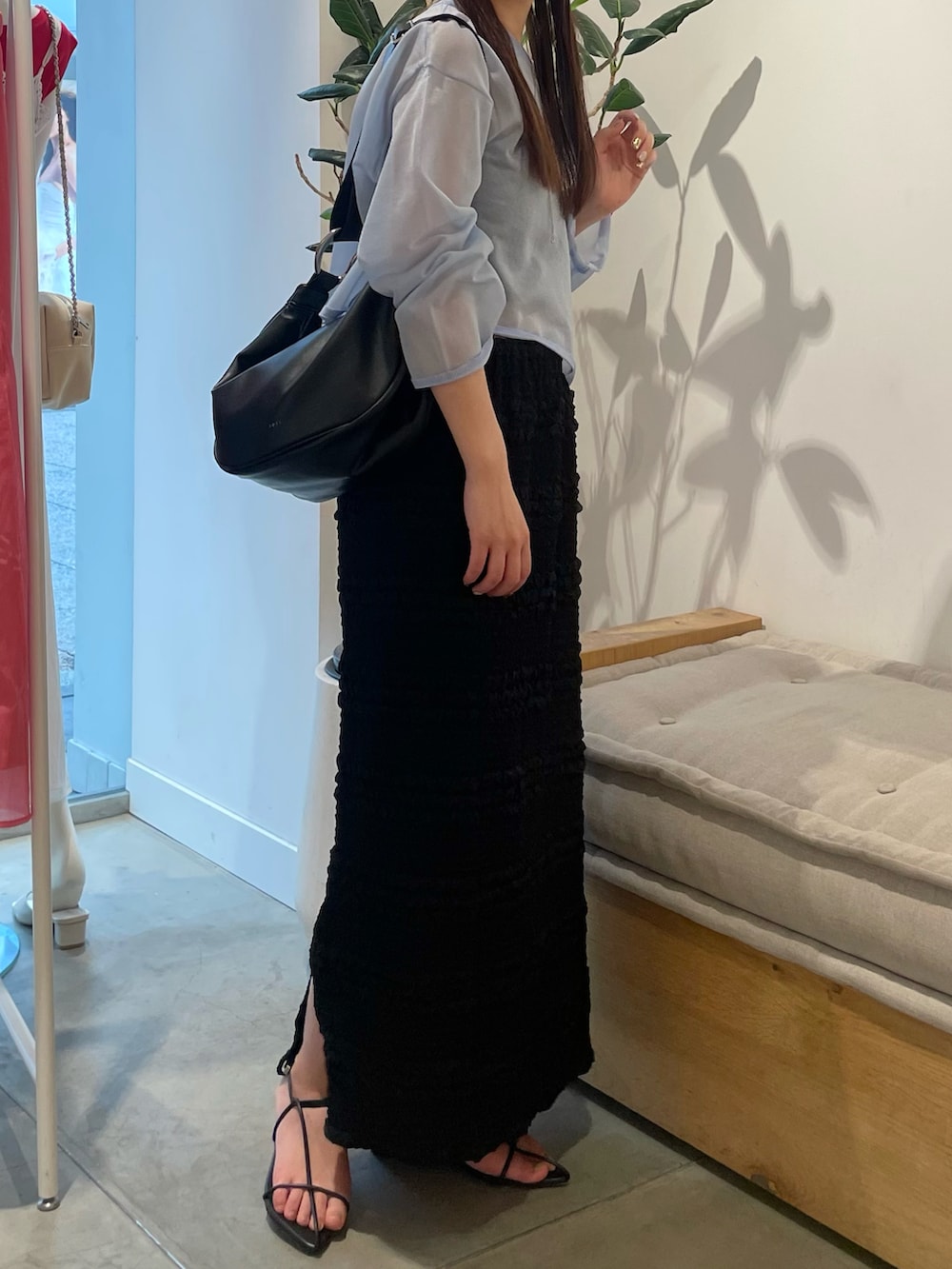 ブルー系のニット/セーター、ブラック系のスカート、ブラック系のサンダルを着用したレディースの夏コーディネートの2枚目の写真