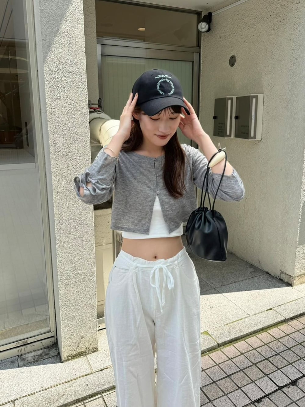 グレー系のTシャツ/カットソー、ホワイト系のその他パンツ、ブラック系のハットを着用したレディースの秋コーディネートの3枚目の写真