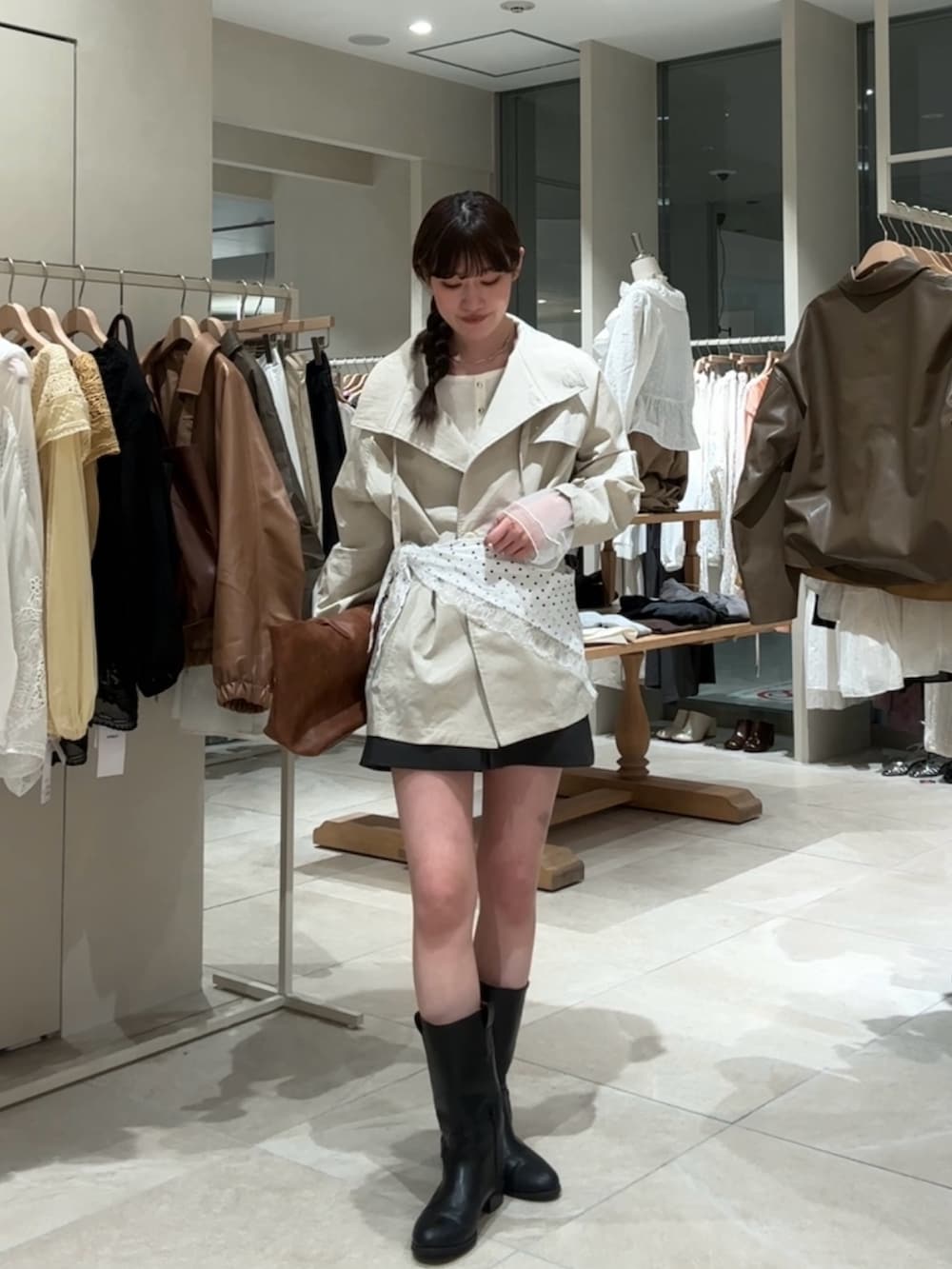 ホワイト系のトレンチコート、グレー系のスカート、イエロー系のトートバッグを着用したレディースの春コーディネートの3枚目の写真