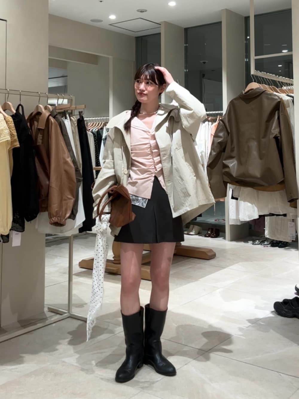 ピンク系のTシャツ/カットソー、ホワイト系のトレンチコート、グレー系のスカートを着用したレディースの春コーディネートの2枚目の写真