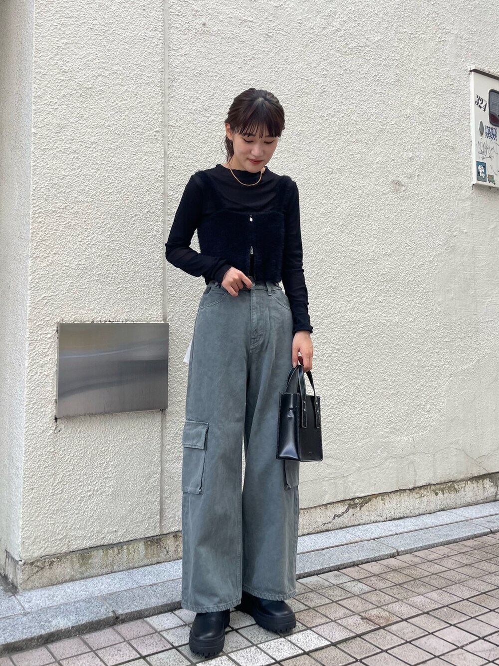 ブラック系のベスト、ブラック系のTシャツ/カットソー、グレー系のデニムパンツを着用したレディースの秋コーディネートの2枚目の写真