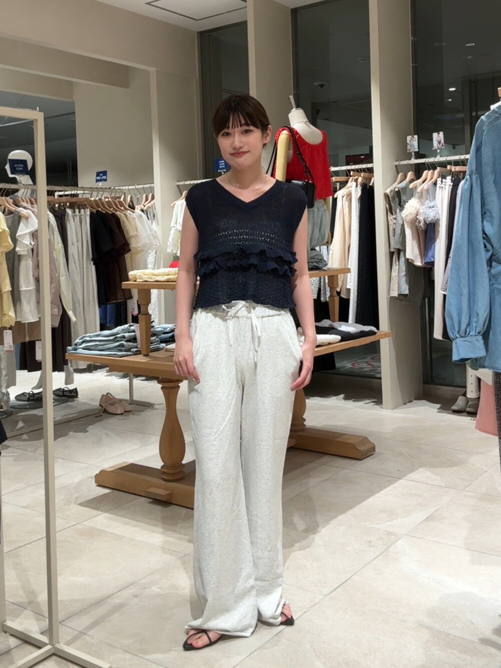 ブルー系のベスト、ホワイト系のスウェットパンツを着用したレディースの夏コーディネートの2枚目の写真