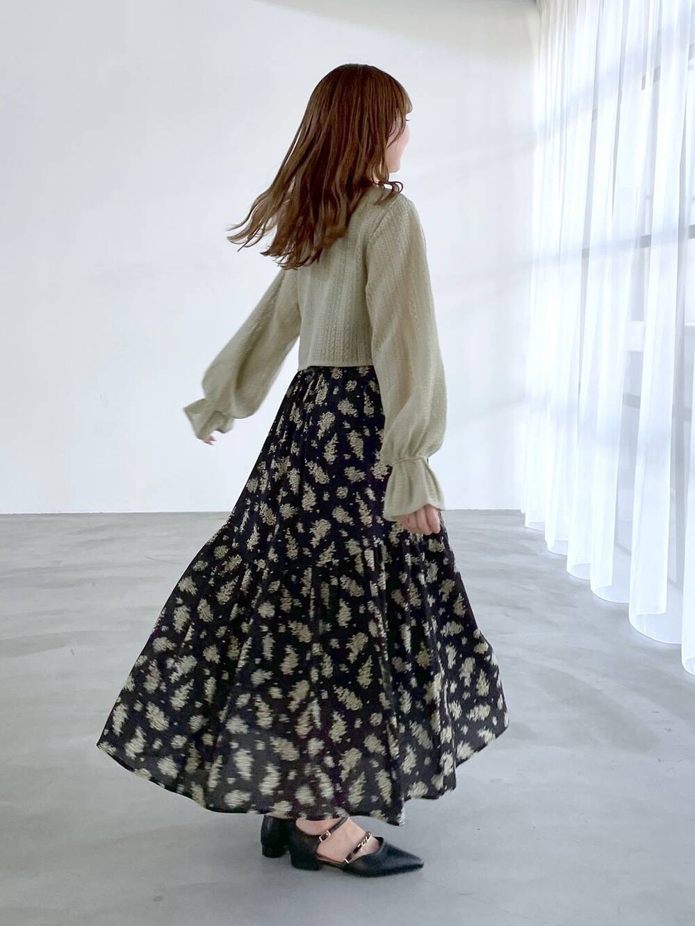 ブラック系のスカート、グリーン系のTシャツ/カットソー、ブラック系のパンプスを着用したレディースの冬コーディネートの2枚目の写真