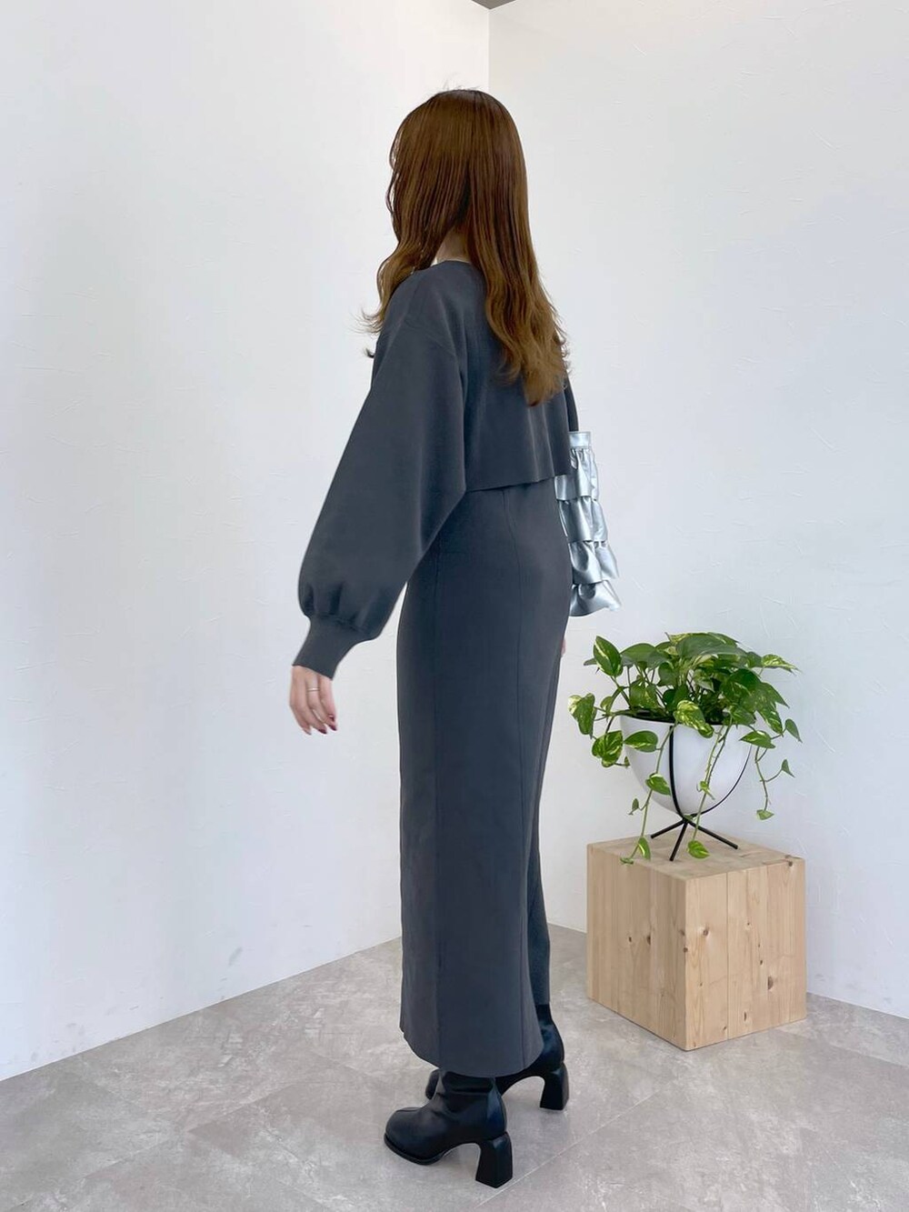 ブラック系のブーツ、シルバー系のトートバッグ、グレー系のワンピースを着用したレディースの冬コーディネートの3枚目の写真