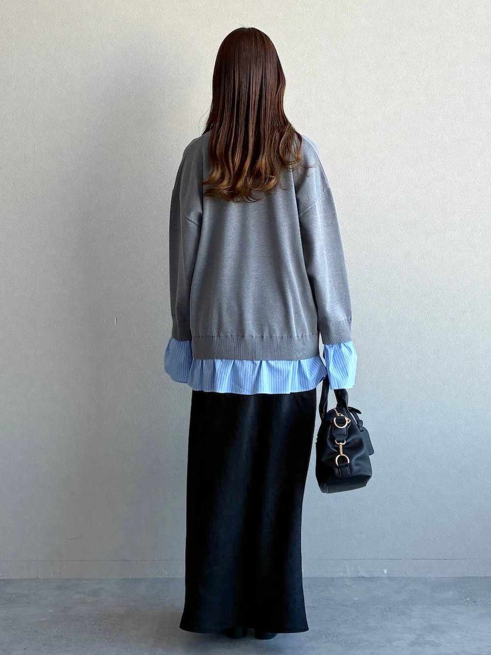 ブラック系のスカート、ブラック系のボストンバッグ、ブラック系のローファーを着用したレディースの冬コーディネートの3枚目の写真