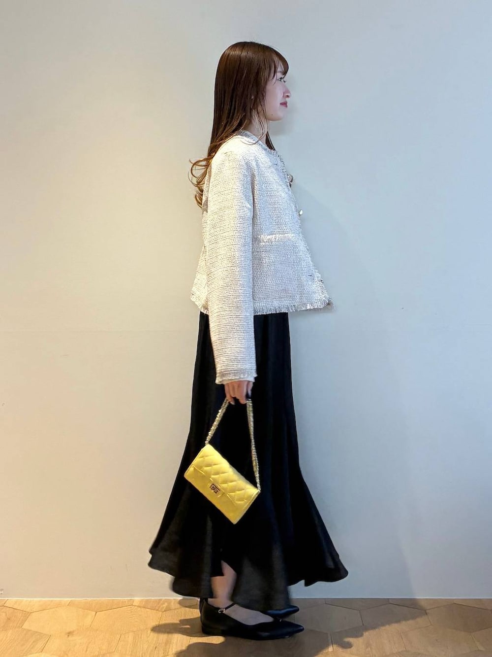 ブラック系のパンプス、ホワイト系のニット/セーター、ホワイト系のノーカラージャケットを着用したレディースの春コーディネートの4枚目の写真