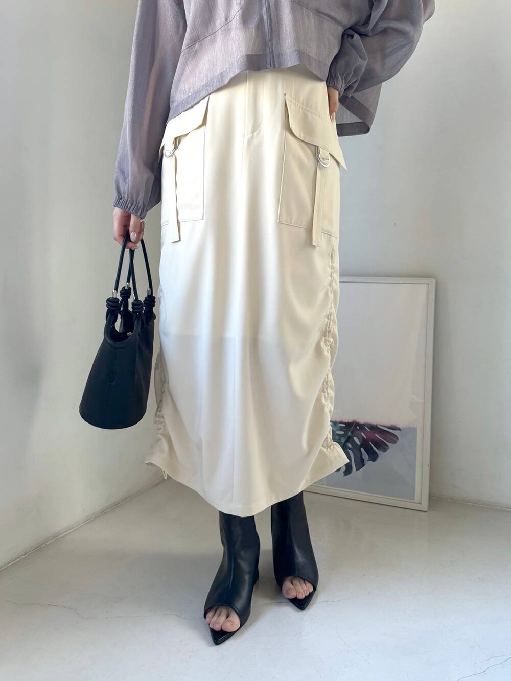 グレー系のパーカー、ブラック系のブーツ、ホワイト系のスカートを着用したレディースの冬コーディネートの5枚目の写真