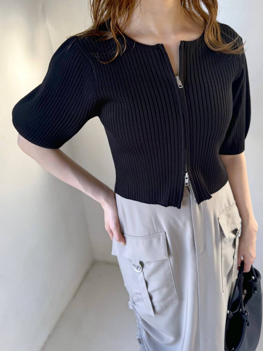 ベージュ系のスカート、ブラック系のサンダル、ブラック系のハンドバッグを着用したレディースの春コーディネートの4枚目の写真