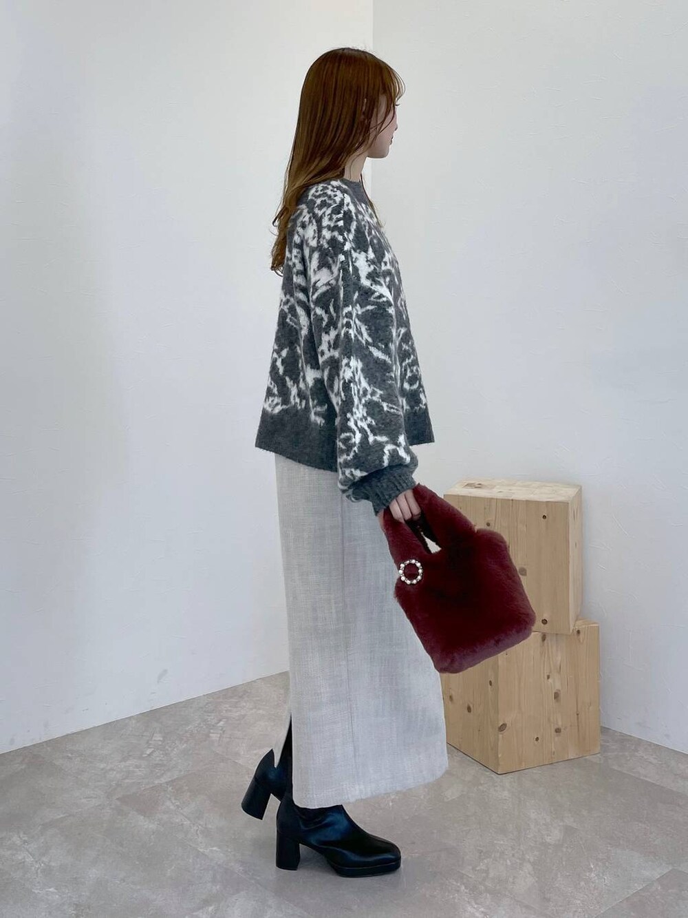 ブラック系のブーツ、ピンク系のハンドバッグ、ホワイト系のスカートを着用したレディースの冬コーディネートの4枚目の写真