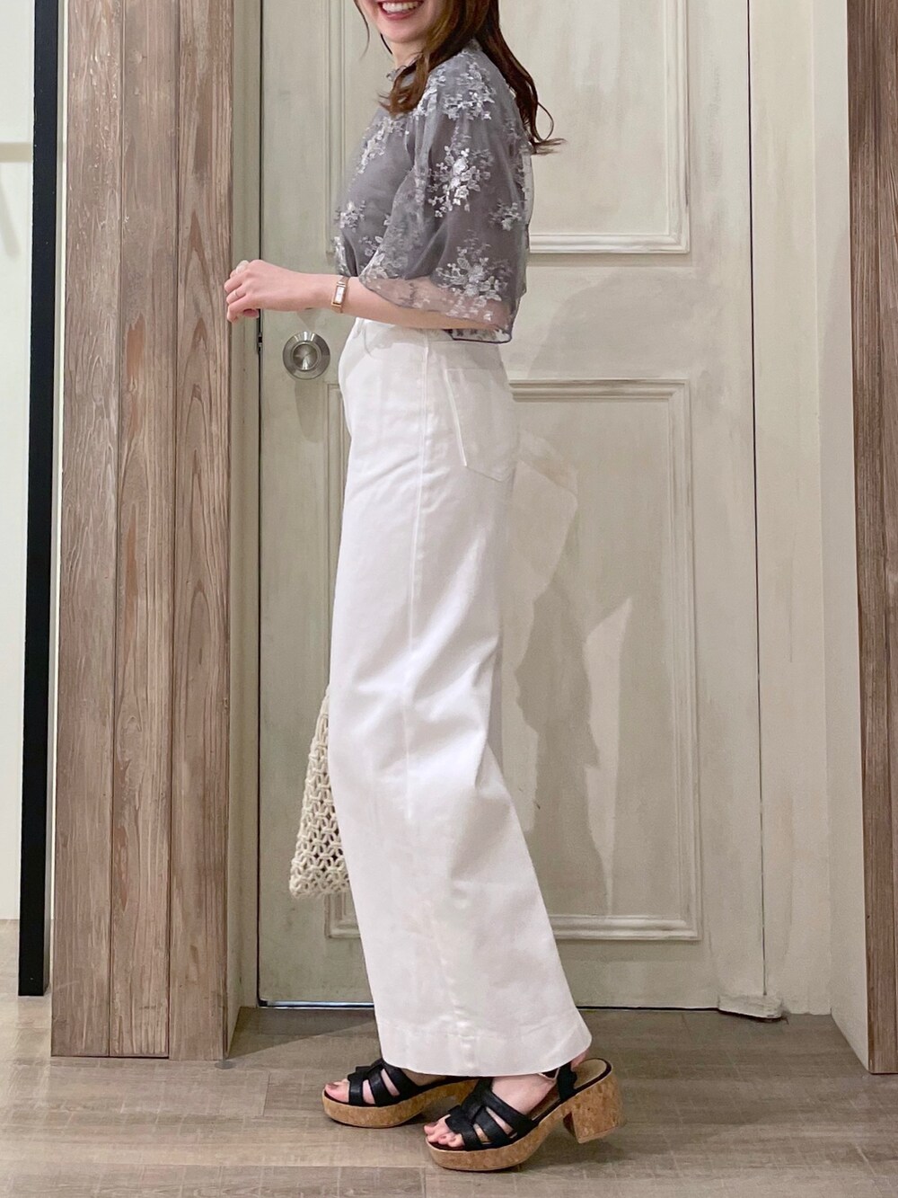 グレー系のシャツ/ブラウス、ホワイト系のタンクトップ、ホワイト系のデニムパンツを着用したレディースの夏コーディネートの2枚目の写真