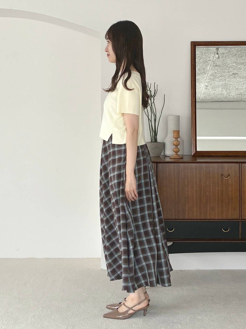 ブルー系のワンピース、ホワイト系のニット/セーター、ブラウン系のサンダルを着用したレディースの夏コーディネートの2枚目の写真