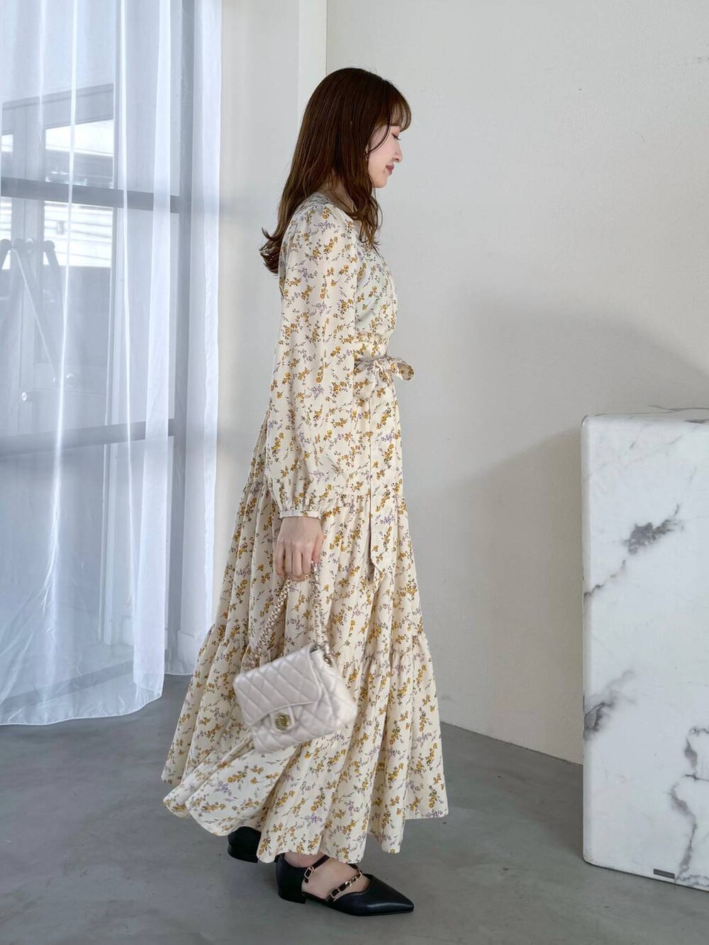 ブラック系のタンクトップ、ホワイト系のショルダーバッグ、ブラック系のパンプスを着用したレディースの冬コーディネートの2枚目の写真