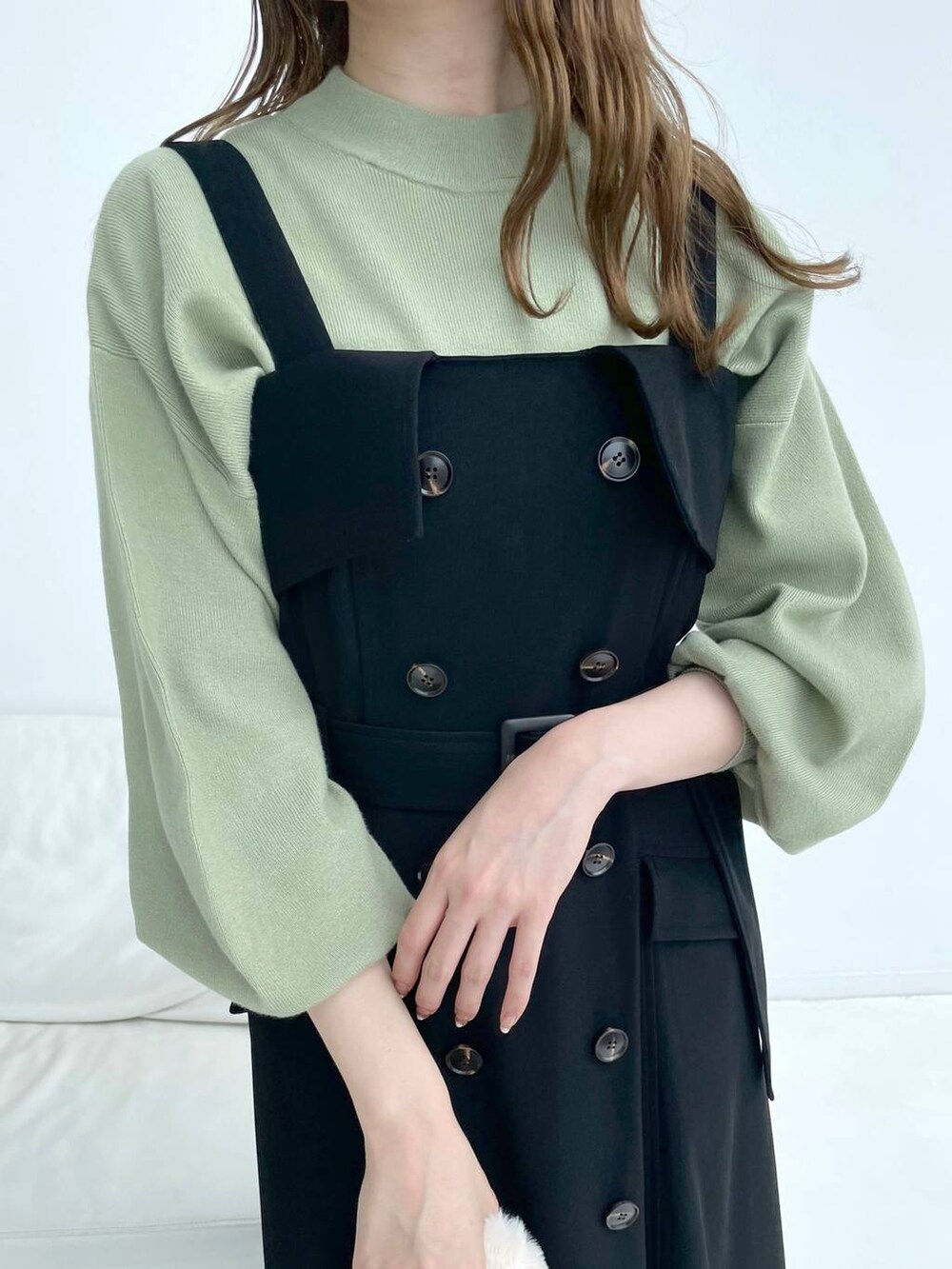 ブラック系のブーツ、ブラック系のジャンパースカート、グリーン系のニット/セーターを着用したレディースの秋コーディネートの5枚目の写真