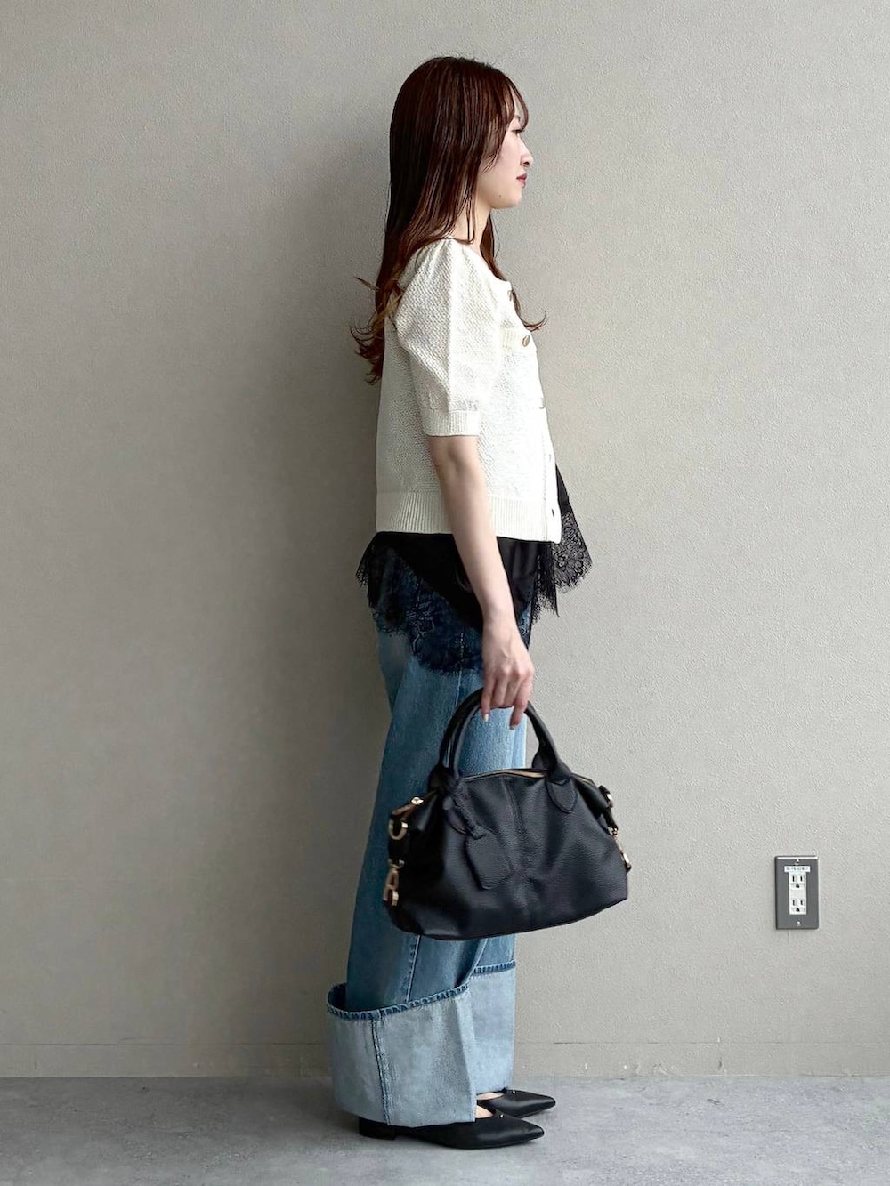 ブラック系のボストンバッグ、ホワイト系のカーディガン/ボレロ、ブラック系のパンプスを着用したレディースの春コーディネートの4枚目の写真