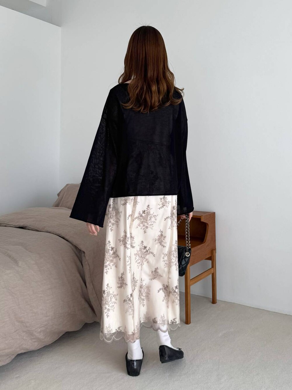 ブラック系のバレエシューズ、ブラック系のショルダーバッグ、ブラック系のニット/セーターを着用したレディースの春コーディネートの2枚目の写真