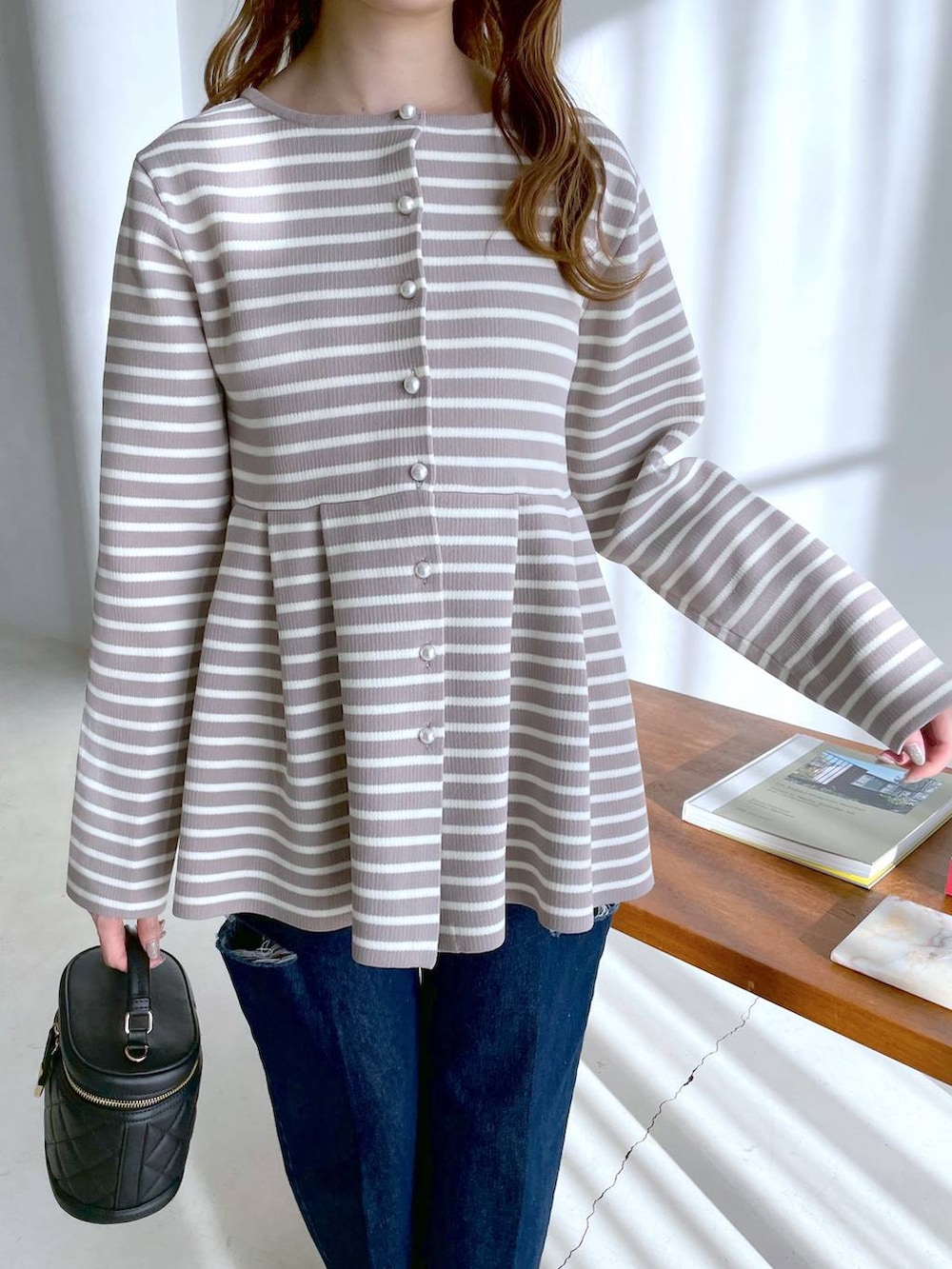 ベージュ系のカーディガン/ボレロ、ブラック系のショルダーバッグ、ブルー系のデニムパンツを着用したレディースの冬コーディネートの3枚目の写真