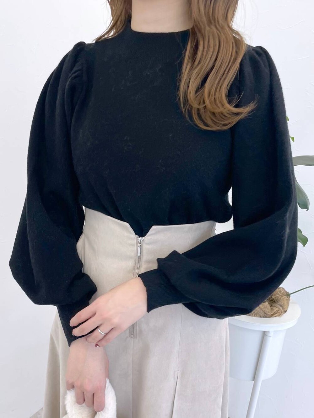 ブラック系のニット/セーター、ブラック系のブーツ、ホワイト系のハンドバッグを着用したレディースの冬コーディネートの4枚目の写真