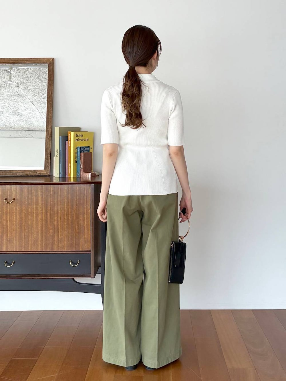 ブラック系のパンプス、ブラック系のショルダーバッグ、ホワイト系のカーディガン/ボレロを着用したレディースの春コーディネートの3枚目の写真