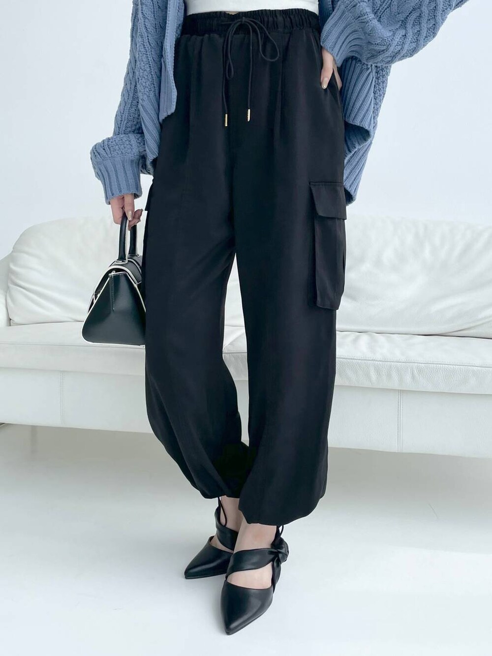 ホワイト系のキャミソール、ブラック系のハンドバッグ、ブラック系のパンプスを着用したレディースの秋コーディネートの6枚目の写真