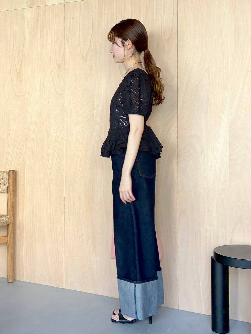 ピンク系のショルダーバッグ、ブルー系のデニムパンツ、ブラック系のシャツ/ブラウスを着用したレディースの春コーディネートの2枚目の写真