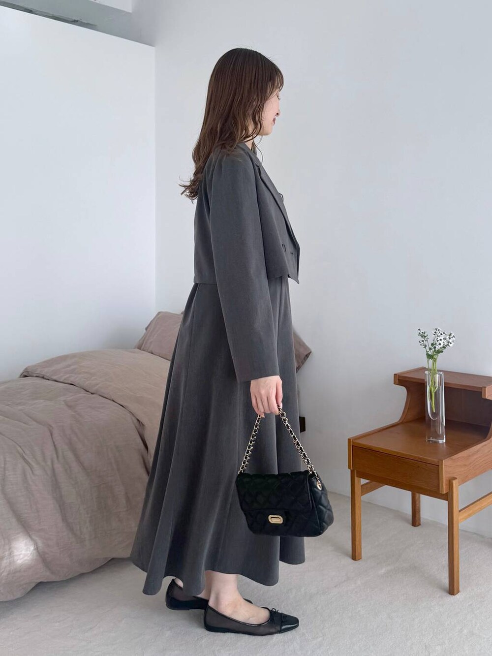 ブラック系のバレエシューズ、グレー系のテーラードジャケット、ブラック系のショルダーバッグを着用したレディースの春コーディネートの2枚目の写真