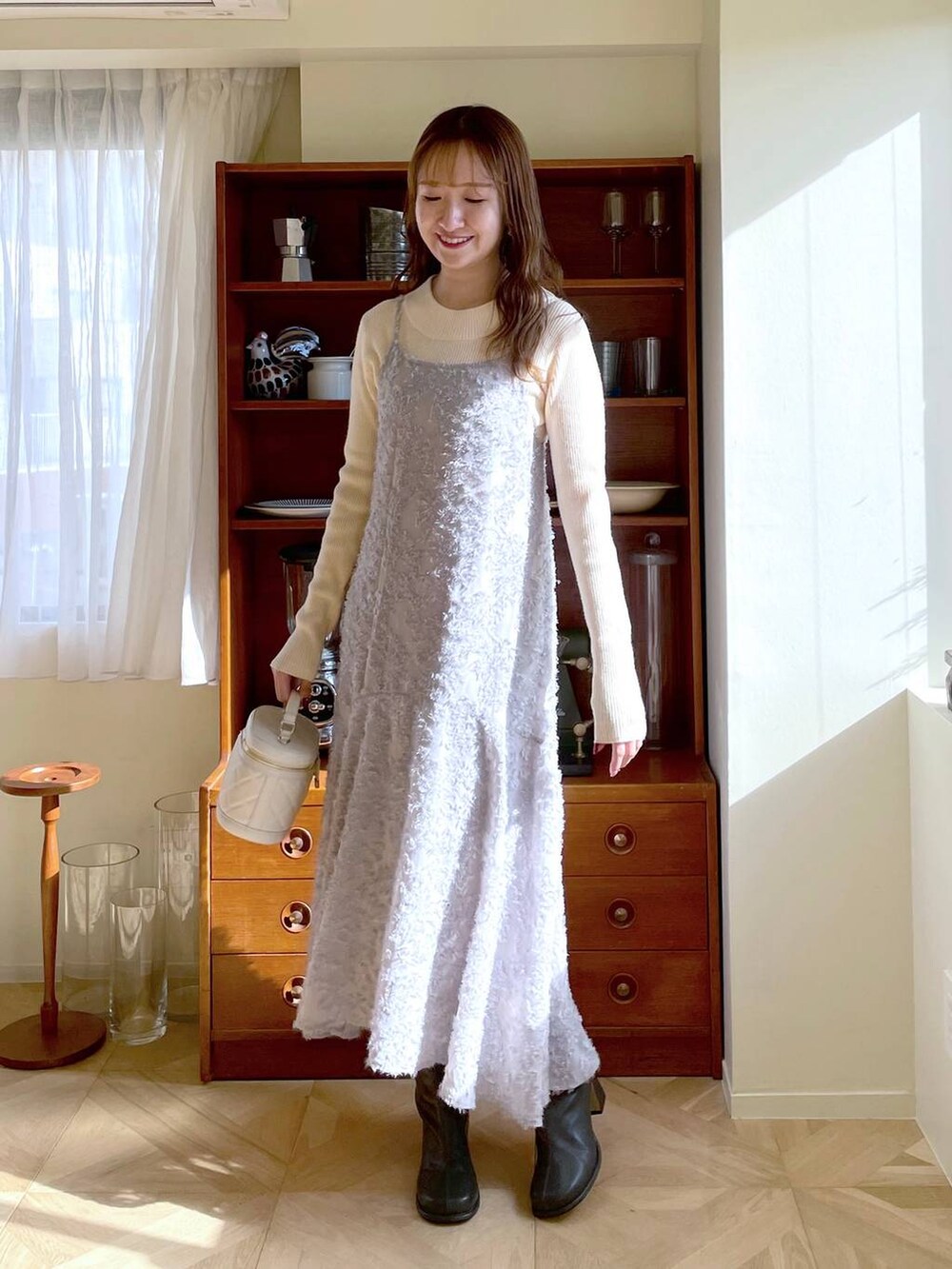 グレー系のブーツ、ホワイト系のニット/セーター、ホワイト系のショルダーバッグを着用したレディースの冬コーディネートの5枚目の写真