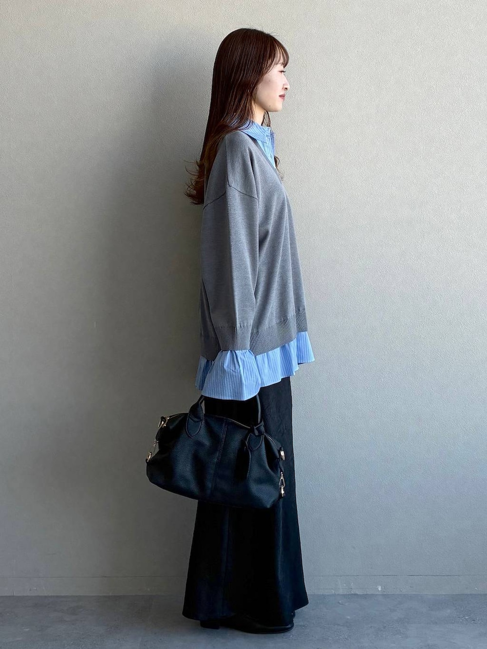 ブラック系のスカート、ブラック系のボストンバッグ、ブラック系のローファーを着用したレディースの冬コーディネートの4枚目の写真