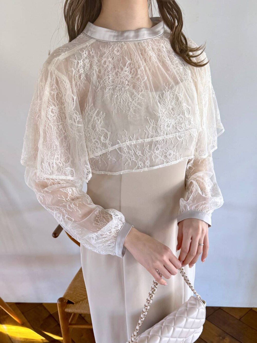 ホワイト系のドレス、ホワイト系のショルダーバッグ、ベージュ系のパンプスを着用したレディースの冬コーディネートの4枚目の写真