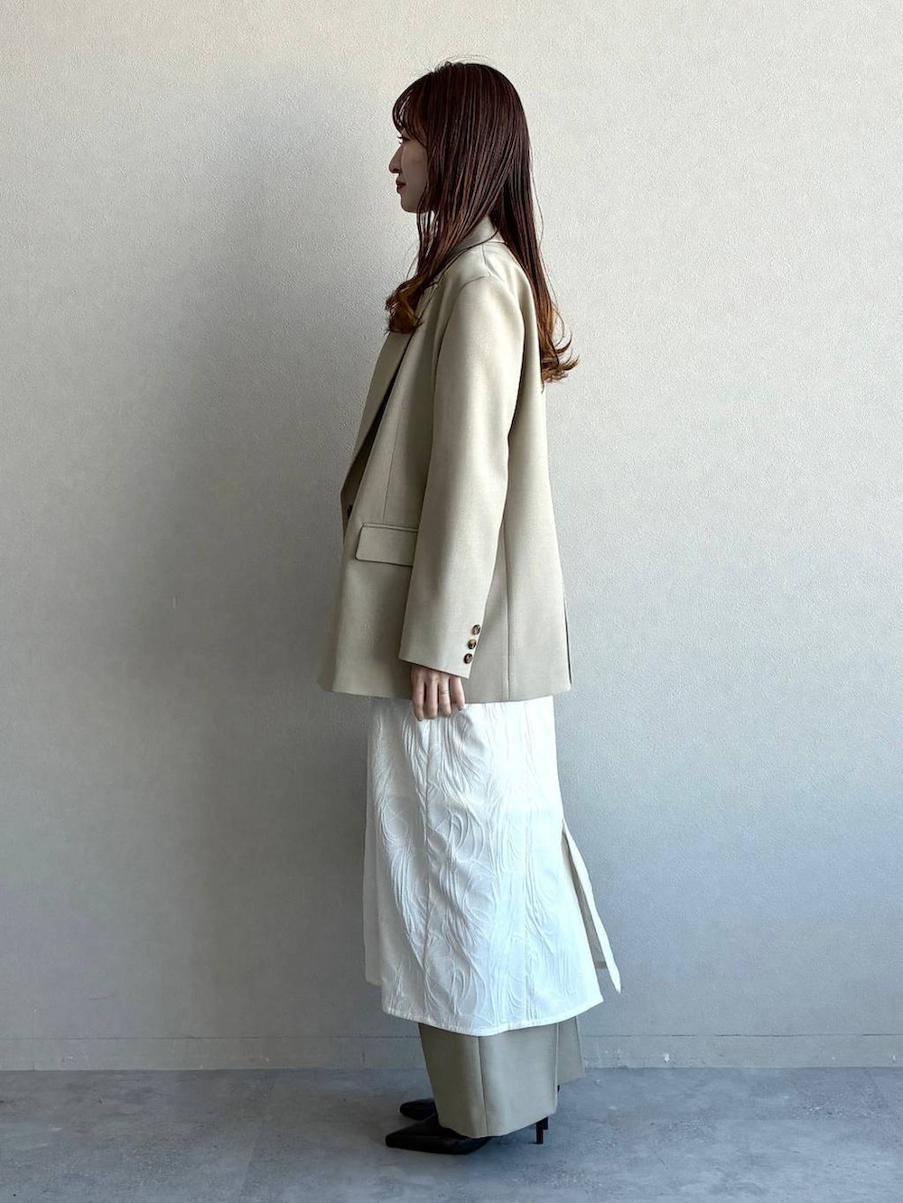 ベージュ系のテーラードジャケット、ベージュ系のその他パンツ、ホワイト系のワンピースを着用したレディースの冬コーディネートの2枚目の写真