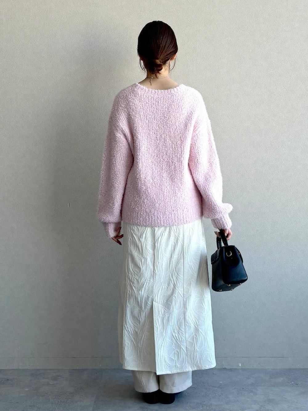 ブラック系のローファー、ブラック系のショルダーバッグ、ピンク系のニット/セーターを着用したレディースの冬コーディネートの3枚目の写真