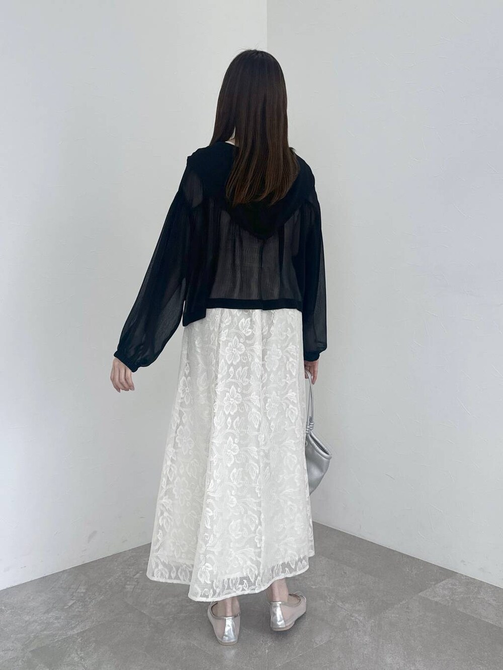 シルバー系のバレエシューズ、ホワイト系のワンピース、ブラック系のパーカーを着用したレディースの春コーディネートの3枚目の写真