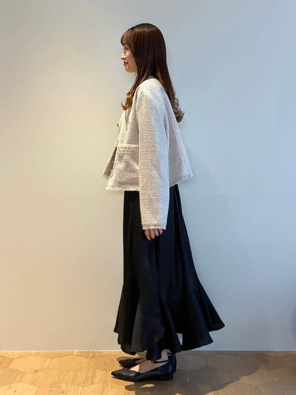 ブラック系のパンプス、ホワイト系のニット/セーター、ホワイト系のノーカラージャケットを着用したレディースの春コーディネートの2枚目の写真