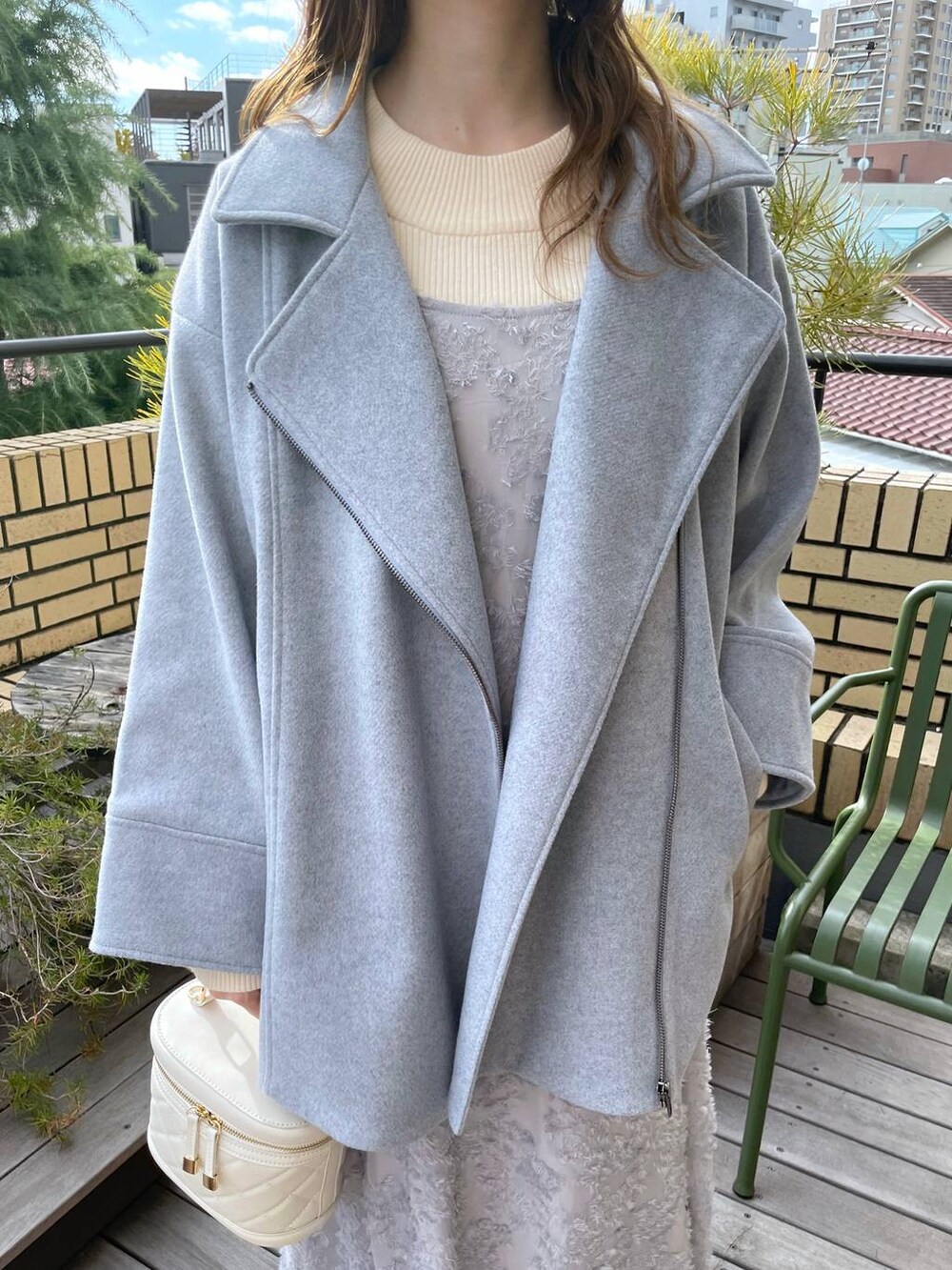 グレー系のブーツ、ホワイト系のニット/セーター、ホワイト系のショルダーバッグを着用したレディースの冬コーディネートの4枚目の写真