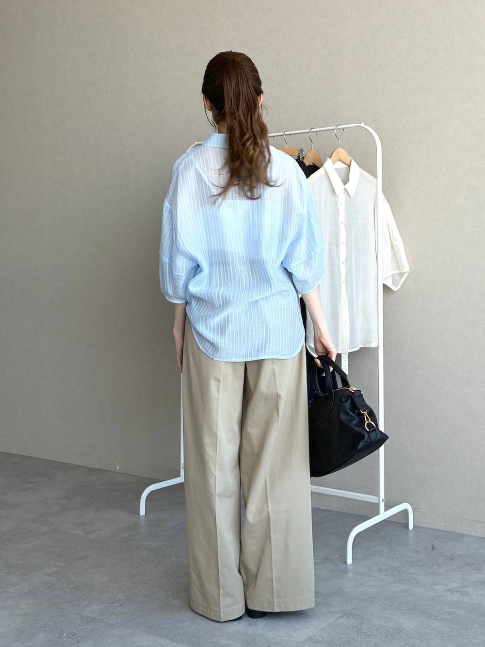 ブラック系のボストンバッグ、ブラック系のローファー、ブルー系のシャツ/ブラウスを着用したレディースの春コーディネートの3枚目の写真