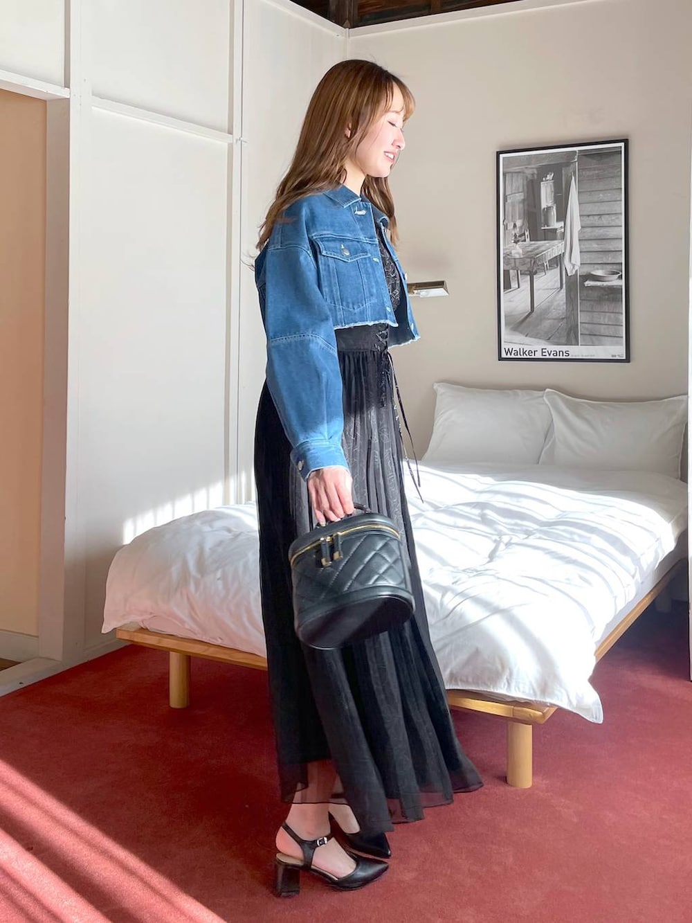 ブラック系のワンピース、ブラック系のショルダーバッグ、ブラック系のパンプスを着用したレディースの冬コーディネートの2枚目の写真