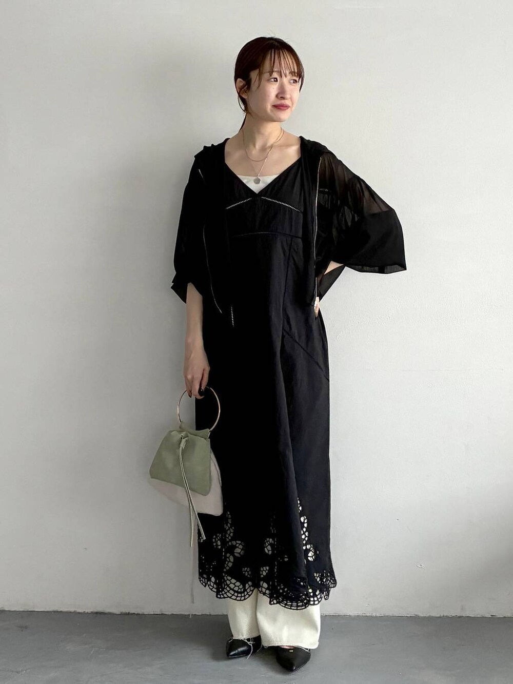 ブラック系のパーカー、ブラック系のパンプス、グリーン系のハンドバッグを着用したレディースの春コーディネートの5枚目の写真