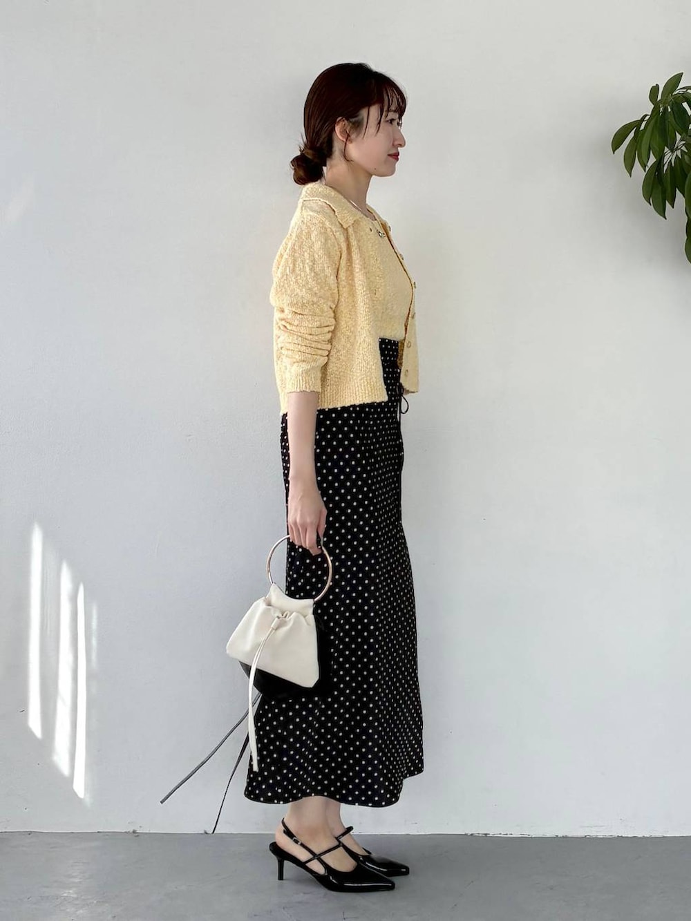 ブラック系のサンダル、イエロー系のカーディガン/ボレロ、ブラック系のスカートを着用したレディースの冬コーディネートの4枚目の写真