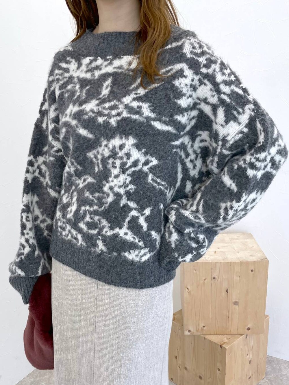 ブラック系のブーツ、ピンク系のハンドバッグ、ホワイト系のスカートを着用したレディースの冬コーディネートの5枚目の写真