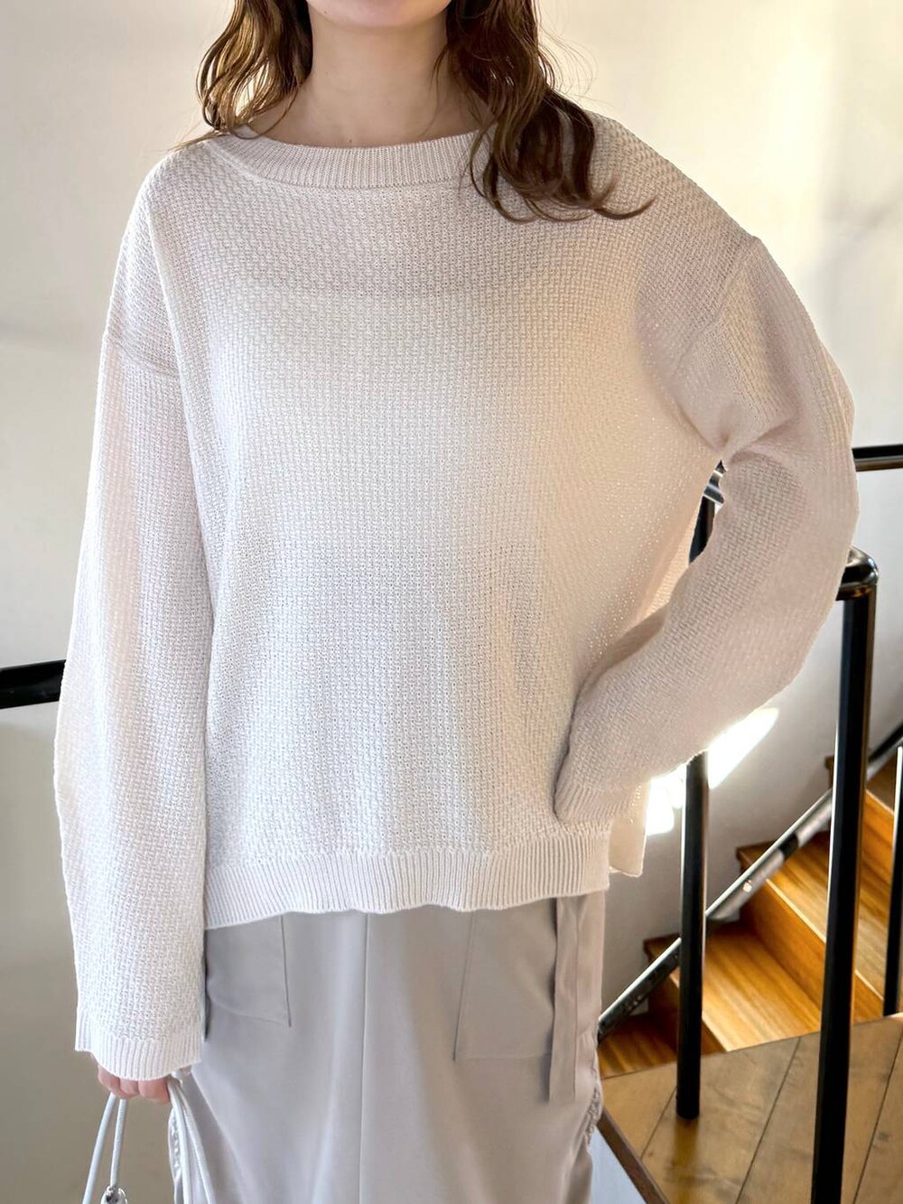 ベージュ系のスカート、ホワイト系のTシャツ/カットソー、ホワイト系のブーツを着用したレディースの冬コーディネートの4枚目の写真