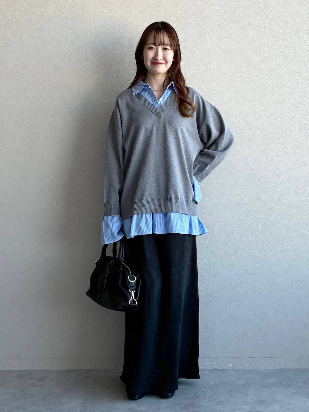 ブラック系のスカート、ブラック系のボストンバッグ、ブラック系のローファーを着用したレディースの冬コーディネートの5枚目の写真