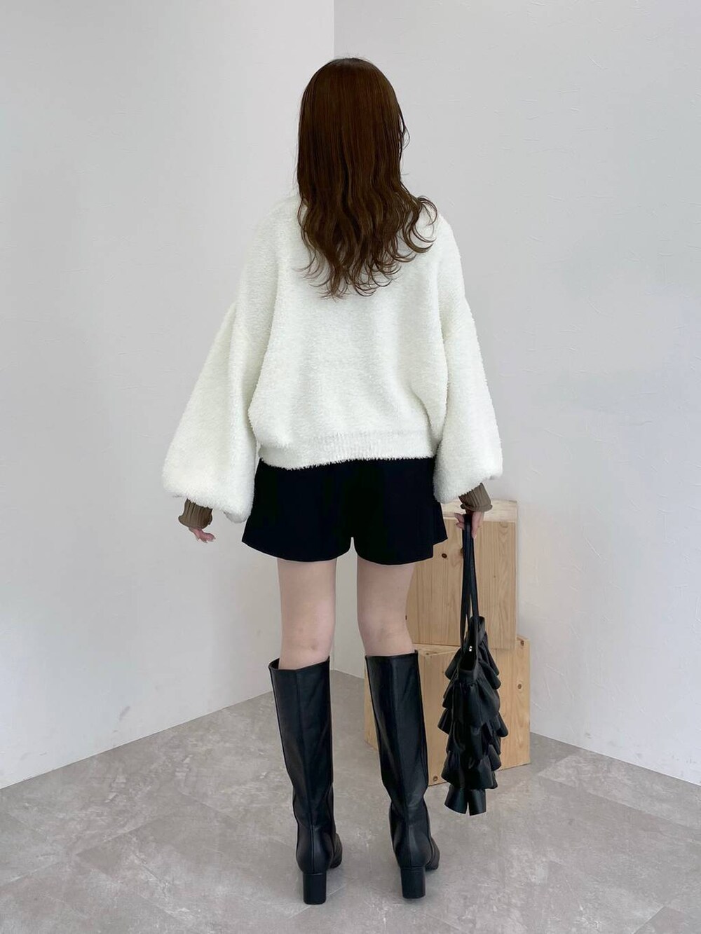 ブラック系のブーツ、ブラウン系のTシャツ/カットソー、ホワイト系のニット/セーターを着用したレディースの秋コーディネートの3枚目の写真