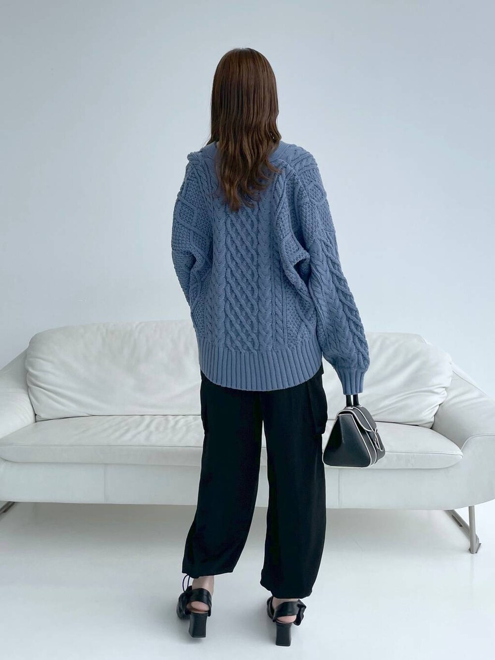 ホワイト系のキャミソール、ブラック系のハンドバッグ、ブラック系のパンプスを着用したレディースの秋コーディネートの3枚目の写真