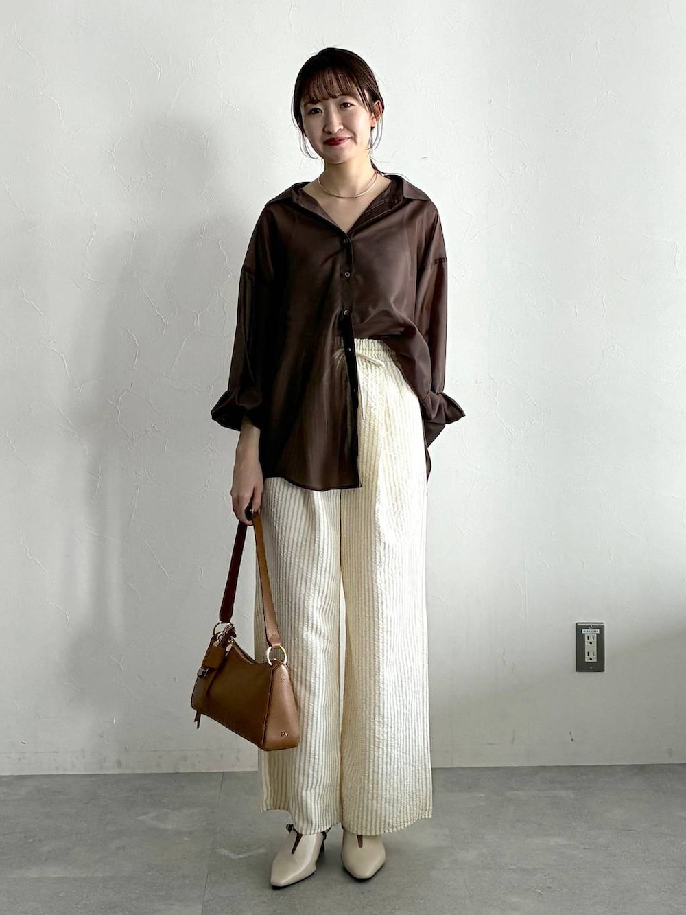 ブラウン系のシャツ/ブラウス、ホワイト系のサンダル、ベージュ系のその他パンツを着用したレディースの春コーディネートの5枚目の写真