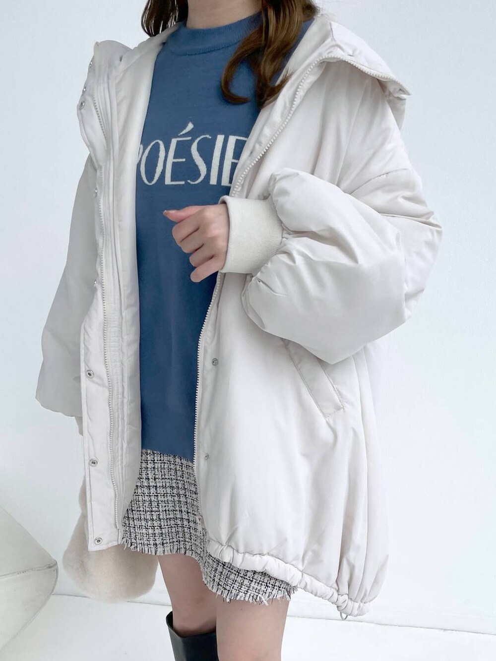 ホワイト系のブルゾン、ブラック系のブーツ、ホワイト系のスカートを着用したレディースの秋コーディネートの5枚目の写真